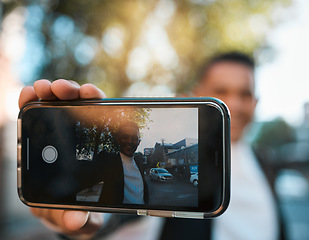 Image showing Selfie, phone screen and business man in city for social media, profile picture and online post. Travel, professional and face of male worker with hand gesture excited for career, job and success