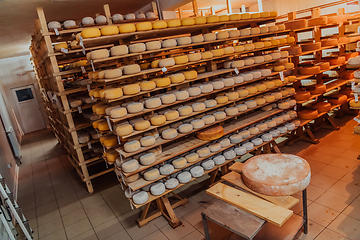 Image showing A large storehouse of manufactured cheese standing on the shelves ready to be transported to markets