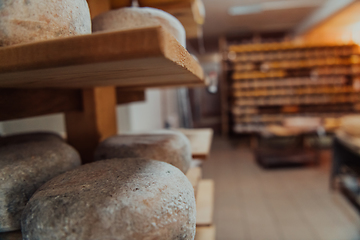 Image showing A large storehouse of manufactured cheese standing on the shelves ready to be transported to markets