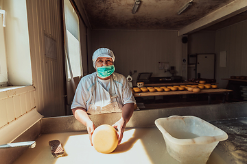 Image showing A woman in the cheese industry. Woman preparing cheese for further processing process in the modern cheese industry