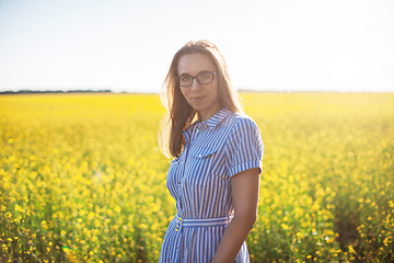 Image showing Beautiful woman in field with yellow flowers