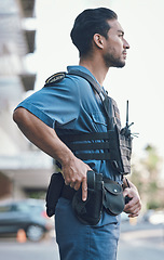 Image showing Security, police and man with gun in city for working, inspection and supervision on patrol shift. Surveillance, law enforcement and male person in urban town for safety, crime and protection service