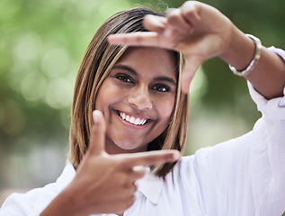 Image showing Portrait, smile and finger frame with a woman in nature, outdoor on a green background for creative photography. Face, photograph and hands with a happy young person in a park for a profile picture