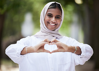 Image showing Hands in heart, park and portrait of Muslim woman for support, love symbol and care outdoors. Happy, emoji and face of Islamic female person with hijab and hand sign for kindness or peace in nature