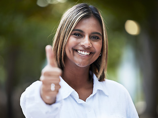 Image showing Portrait, smile and thumbs up with a woman in nature, outdoor on a green background for support or motivation. Face, thank you and like emoji with a happy young person standing in a park to say yes