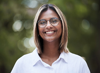 Image showing Portrait, smile and glasses with a woman in nature, outdoor on a green background for travel or freedom. Face, eyewear and a happy young female person standing in a park for vision or eyesight