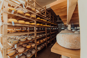 Image showing A large storehouse of manufactured cheese standing on the shelves ready to be transported to markets