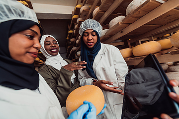 Image showing Arab business partners checking the quality of cheese in the industry and enter data into a laptop. Small business concept