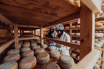 Image showing Arab business partners checking the quality of cheese in the industry and enter data into a laptop. Small business concept