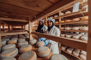 Image showing Arab business partners checking the quality of cheese in the industry and enter data into a laptop. Small business concept