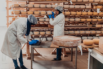 Image showing Muslim business partners checking the quality of cheese in the modern industry