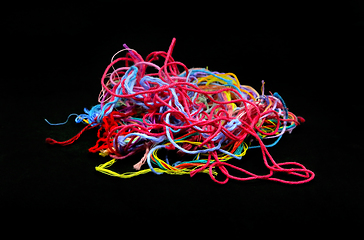 Image showing Multicolored tangled threads for needlework close-up on black ba