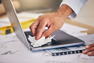 Image showing Hand with cloth, keyboard on laptop and cleaning dust or dirt from workspace with blueprint and architecture. Wiping, tissue and engineer with computer cleaner for safety care, caution and paperwork.