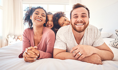 Image showing Portrait, happy family and relax on a bed, bond and having fun on the weekend in their home together. Interracial, love and face of playful children with parents in a bedroom, smile and playing games