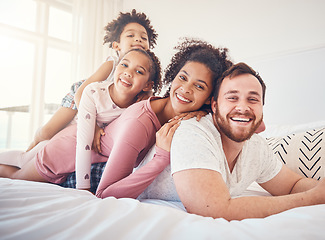 Image showing Happy family, portrait and relax on a bed, bond and having fun on the weekend in their home together. Interracial, love and face of playful children with parents in a bedroom, smile and playing games