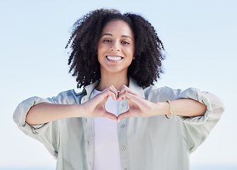 Image showing Woman, heart hands and portrait on beach, happiness and support with emoji, travel and wellness with health outdoor. Adventure, love sign and female person with smile, peace and calm with care