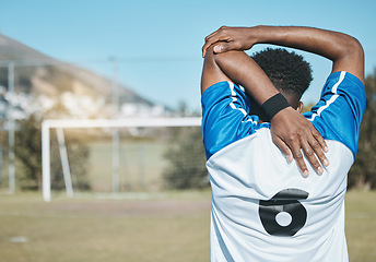 Image showing Man, soccer and stretching arm in fitness commitment for match, game or training on grass field outdoors. Rear view of person or sports athlete in body warm up for healthy start or football practice