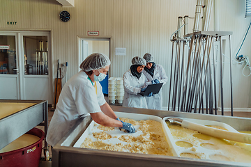 Image showing Arab business partners oversee cheese production in modern industry