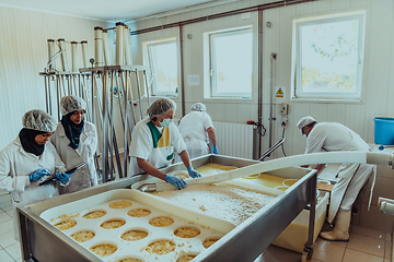 Image showing Arab business partners oversee cheese production in modern industry
