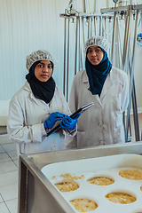 Image showing Arab business partners checking the quality of cheese in the industry and enter data into a laptop. Small business concept