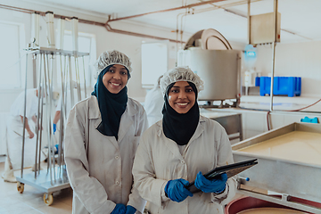 Image showing Arab business partners checking the quality of cheese in the industry and enter data into a laptop. Small business concept