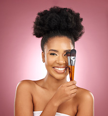 Image showing Portrait, makeup and black woman with brushes, skincare and dermatology against a pink studio background. Female person, aesthetic or model with cosmetic tools, natural beauty or shine with self care