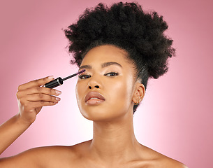 Image showing Mascara, makeup and beauty portrait of a woman for skincare, wellness and dermatology glow. Volume, eyelash and face cosmetics of a black female model with facial shine on a pink background in studio