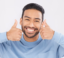 Image showing Thumbs up, portrait and asian man happy in studio with hand, sign and thank you on grey background. Smile, face and Japanese male with finger emoji for yes, vote or positive review, feedback or agree