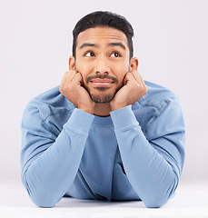 Image showing Memory, thinking and young man in a studio resting on his arms with a problem solving facial expression. Happy, smile and Indian male model with question or dream face isolated by a white background.