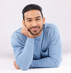 Image showing Fashion, portrait and confident man on the floor in studio isolated on a white background. Face, style and young Asian model in casual clothes, trendy aesthetic and relax on the ground in Cambodia