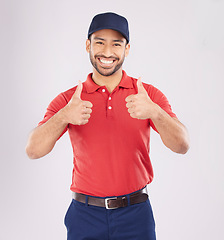 Image showing Thumbs up, smile and portrait of a happy man in studio with a hand sign for support or thank you. A young asian person on a white background for fashion clothes, like emoji and review or feedback