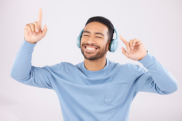 Image showing Headphones, energy and man doing a dance in a studio with music, album or playlist with technology. Happy, smile and Indian young male model dancing to song or radio isolated by a white background.