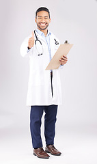 Image showing Asian man, doctor and portrait with thumbs up for healthcare approval against a white studio background. Happy male person or medical expert smile with clipboard, like emoji or yes sign for success