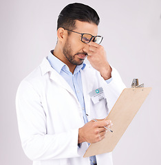 Image showing Stress, checklist and man doctor in a studio for a medical diagnosis or wellness treatment. Burnout, headache and male healthcare worker with a migraine for clipboard isolated by a gray background.