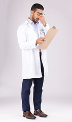 Image showing Burnout, clipboard and man doctor in a studio for a medical diagnosis or wellness treatment. Stress, headache and male healthcare worker with a migraine for checklist isolated by a gray background.