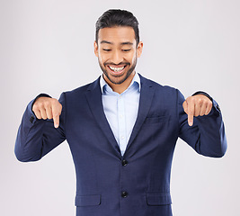 Image showing Down, hand pointing and asian man in studio with sale, announcement or coming soon promo on grey background. Smile, news and Japanese male show launch, platform and giveaway, process or contact info