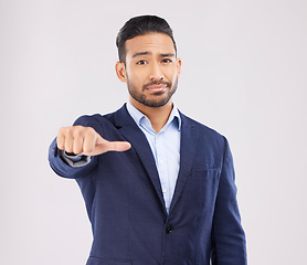 Image showing Review, portrait and a marketing businessman with a hand on a studio background for feedback. Choice, sign language and an Asian employee with a thumb gesture for a decision isolated on a backdrop