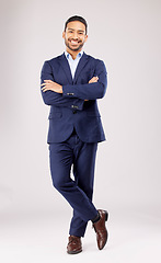 Image showing Business man, arms crossed and smile in studio portrait for pride, success or suit by white background. Young asian entrepreneur, happy and excited for finance company, accounting and fashion for job