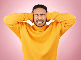 Image showing Man, headache and cover ears for stress or mental health of student frustrated on a pink background. Angry, anxiety and fear or scared young person with hands to stop noise or sound in studio