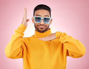 Image showing Man, funny dancing and sunglasses for portrait, studio and smile, hands and clothes for aesthetic by pink background. Asian gen z student, happy and color lens for fashion, dance and frame for face