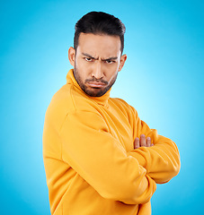 Image showing Portrait, frown and asian man with arms crossed in studio angry, frustrated and annoyed on blue background. Conflict, anger and face of Japanese male with defensive body language, denial or offended