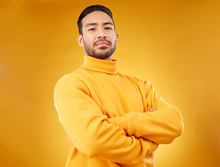 Image showing Fashion, winter and portrait of man with arms crossed for style, cool and trendy aesthetic. Yellow, handsome and Asian person or model with confidence, pride and power on a studio background