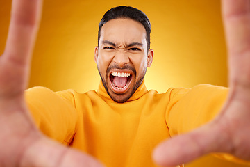 Image showing Shouting, portrait and selfie of angry man in studio isolated on a yellow background. Face, screaming and Asian person taking profile picture for memory in anger, frustrated or stress on social media