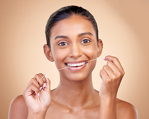 Image showing Woman, mouth and flossing in studio portrait with smile, cleaning or teeth whitening by brown background. Girl, model and happy for dentistry product, string or self care for tooth, beauty or health