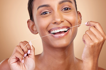 Image showing Woman, tooth and floss in studio portrait with smile, cleaning or self care by brown background. Girl, model and happy for dentistry product, string or teeth whitening for cosmetics, beauty or health