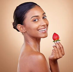 Image showing Portrait, woman with a strawberry and skincare with natural beauty in studio or benefits in healthy nutrition, diet or fruit. Girl, eating or food with vitamin c for skin to glow or wellness of body
