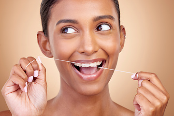 Image showing Woman, dental floss and studio for thinking, smile and cleaning for teeth whitening by brown background. Girl, model or happy for dentistry product, ideas or self care for cosmetic, beauty or health