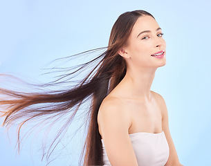 Image showing Portrait, hair and beauty with a model woman in studio on a blue background for shampoo or keratin treatment. Spa, salon or hairdresser with an attractive young female person posing for haircare