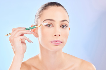 Image showing Makeup, portrait and woman with brush on eyes on blue background for cosmetics and skincare. Mascara tools, eyelash and natural beauty, face of model with eye product application on lashes in studio.