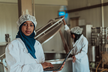 Image showing Arab business partners checking the quality of cheese in the industry and enter data into a laptop. Small business concept